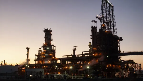 Oil refinery sillhouetted against evening sky.