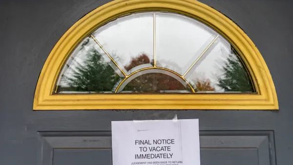 Eviction notice taped to dark grey door with arched window at top.