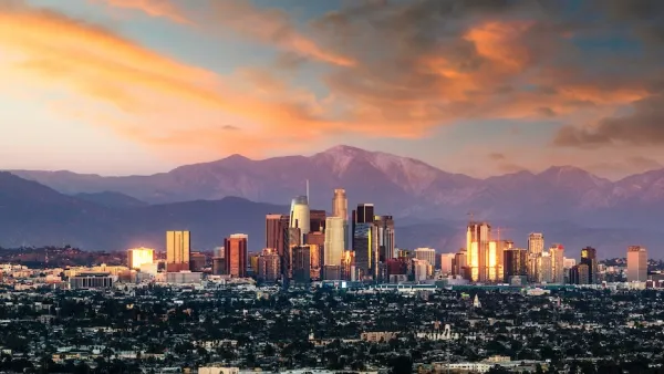 Los Angeles, California skyline against mountains at sunset.
