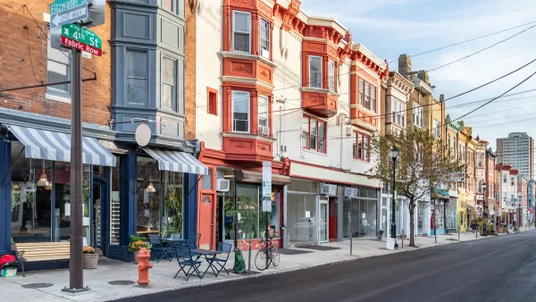Row of three-story buildings with stores and restaurants with awnings on ground floor in Philadelphia, Pennsylvania.