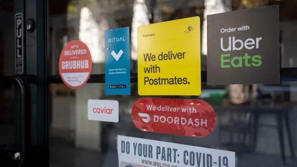 Close-up of restaurant window with various food delivery company stickers