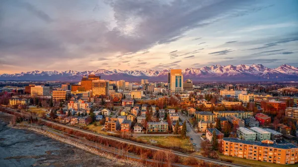 Aerial view of Anchorage, Alaska downtown with mountains in background at golden hour.