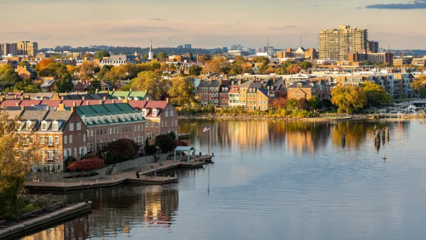 View of Alexandria, Virginia with brick three-story townhomes on Potomac River bank.