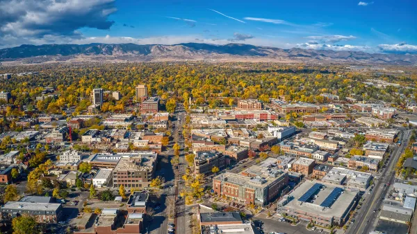 Aerial view of Fort Collins, Colorado on sunny day with mountains in background.