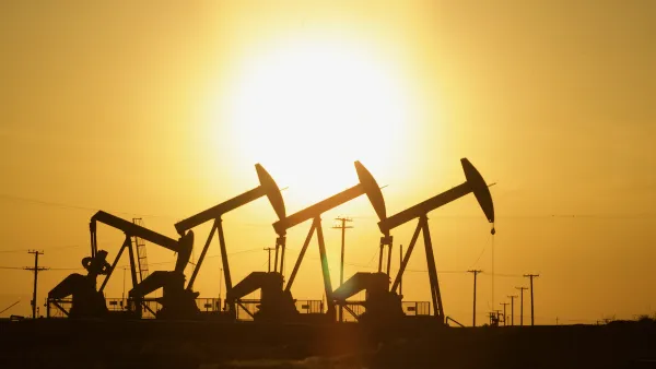 Four oil wells sillhouetted against the sunset.