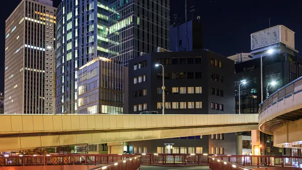Vacant pedestrian overpass and skyscrapers in downtown financial district at night.
