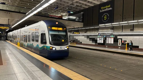 White and blue Seattle Link light rail train pulling into station in Seattle, Washington.