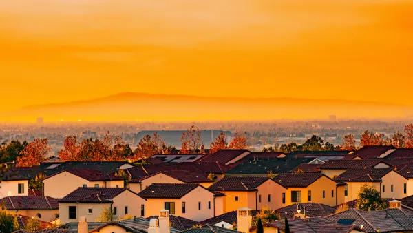 View of Spanish-style homes in dense neighborhood in Orange County, California at sunset.