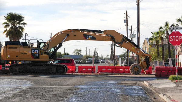 Yellow Cat heavy equipment working on light rail construction on road in Phoenix, Arizona.