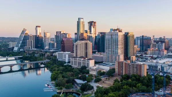 View of Austin, Texas skyline with river in foreground during morning golden hour.
