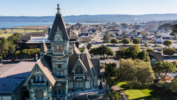 Ornate Victorian home in foreground and neighborhood in Eureka, California.
