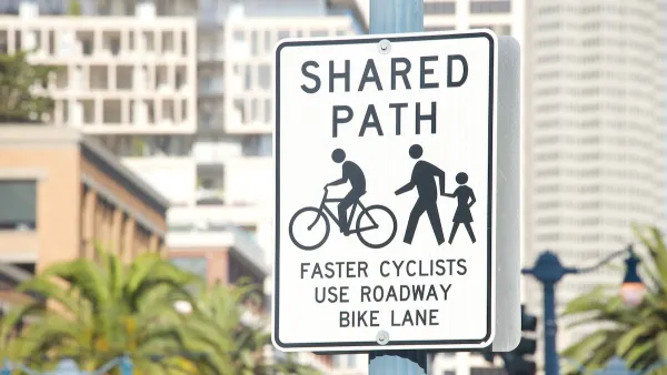 Close-up of "Shared Use Path" sign for pedestrians and cyclists on post in urban setting.
