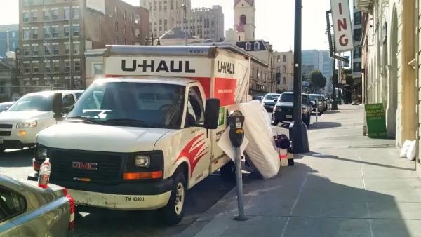 U-Haul moving van parked by a curb in San Francisco with mattress leaning against it