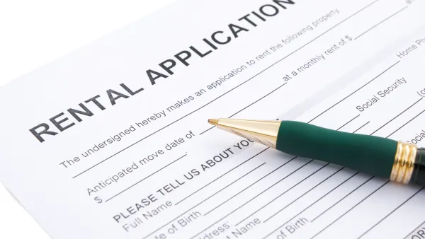 Close-up of rental application laying on table with green pen laying across the paper