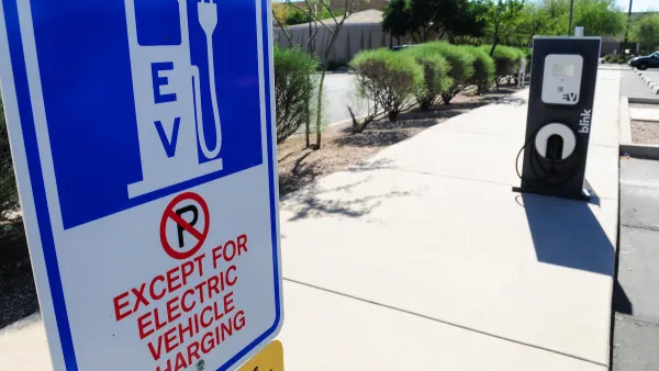 Close-up of EV charging station sign with "No Parking except for EV charging" in outdoor parking lot.