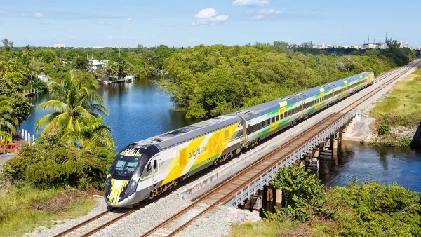 Aerial view of yellow Brightline high-speed rail train in Deerfield Beach, Florida.
