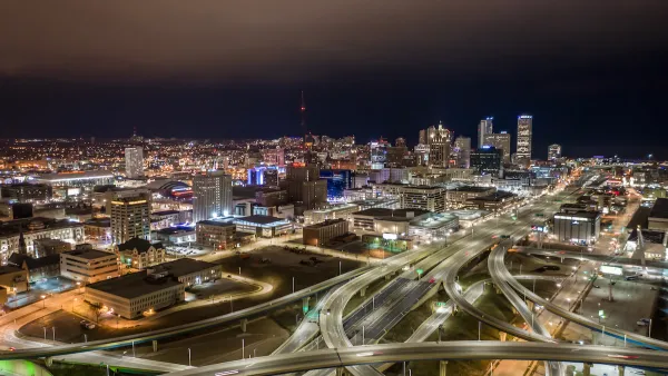 Aerial view of Milwaukee, Wisconsin skyline with freeway interchanges in foreground at night.