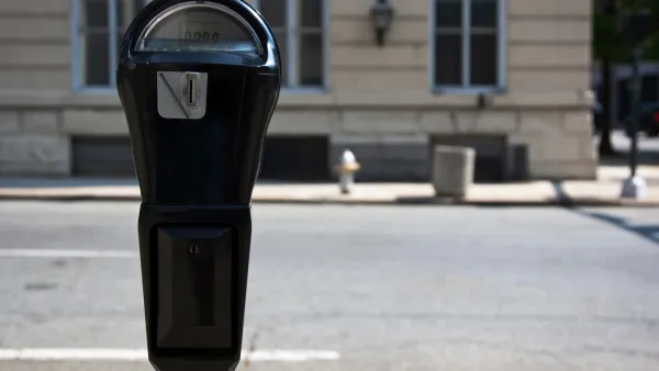 Close-up of black parking meter with blurred street in background