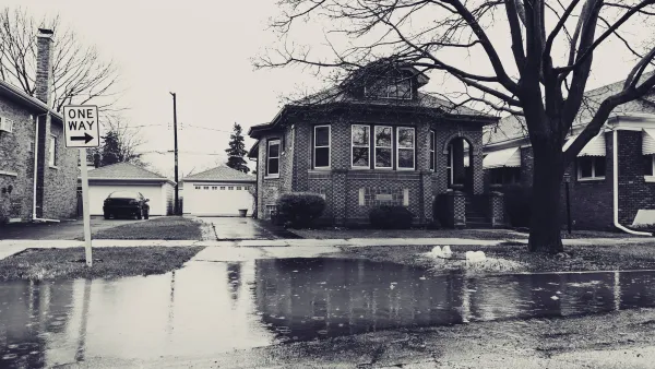 Sepia-toned photo of flooded street with residential home