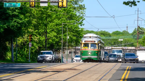 Vintage green Phialdelphia trolley moving down street