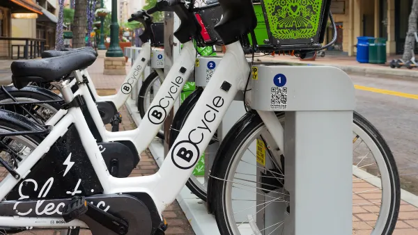 B-cycle bike share station with white bikes on street in San Antonio, Texas.