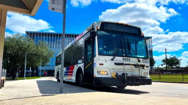 Houston Metro bus at a bus stop with bright blur cloudy sky in background