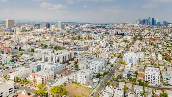 Aerial view of Koreatown neighborhood in Los Angeles with downtown skyline in background.