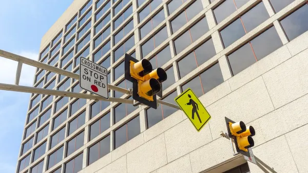 Low angle view of a pedestrian crosswalk traffic signal lights in a city.