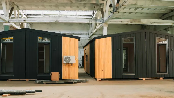 Two black modular units with glass doors and wood accents in an industrial warehouse.