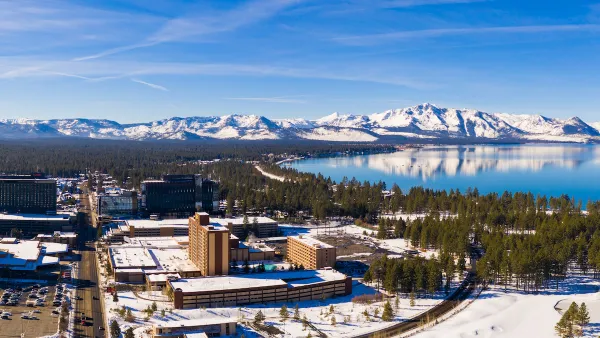 Aerial view of snowy town of Stateline, Nevada on shore of Lake tahoe with mountains in background.