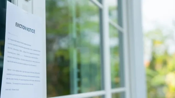 Close-up of eviction notice taped on house door.