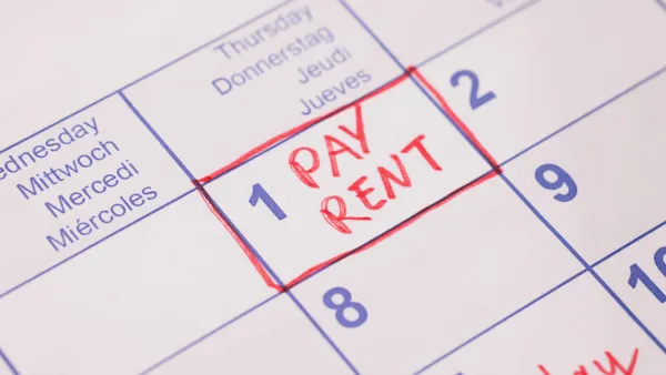 Close-up of 'Pay rent' note in red marker on day 1 of monthly calendar.