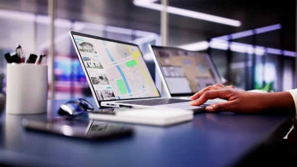 Close-up of hand on laptop keyboard with real estate listings and map pulled up on screen.