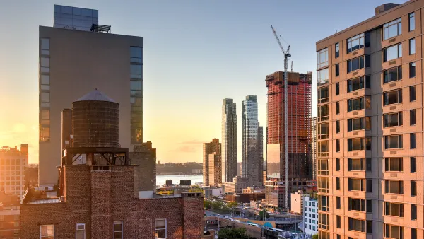 View of high-rise buildings and construction cranes in midtown Manhattan against sunset sky