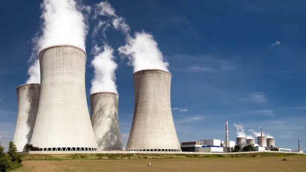 Nuclear power plant with four massive towers emitting white vapor.