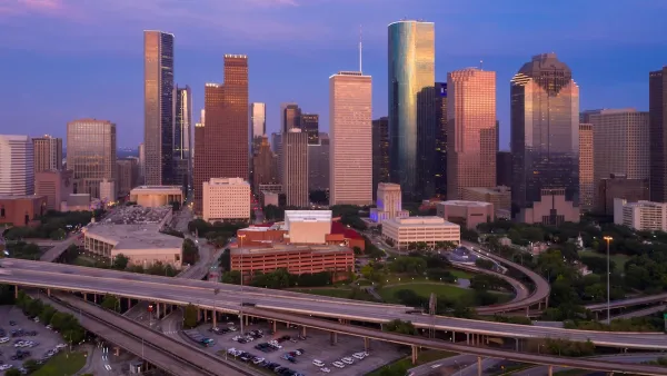 View of downtown Houston with elevated freeways in foreground at dusk.