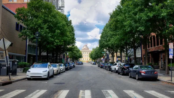 Crosswalk on street in Raleigh, North Carolina with parking on both sides and capitol building visible in background.
