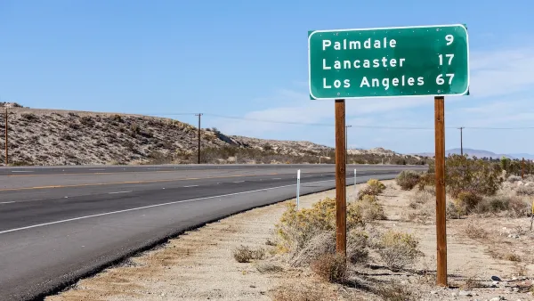 Green highway sign with white text with distances for Palmdale, Lancaster, and Los Angeles, California.