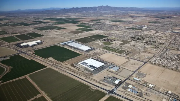Sprawling warehouses and agricultural landscapes mix with low-rise residential developments in the Arizona desert.