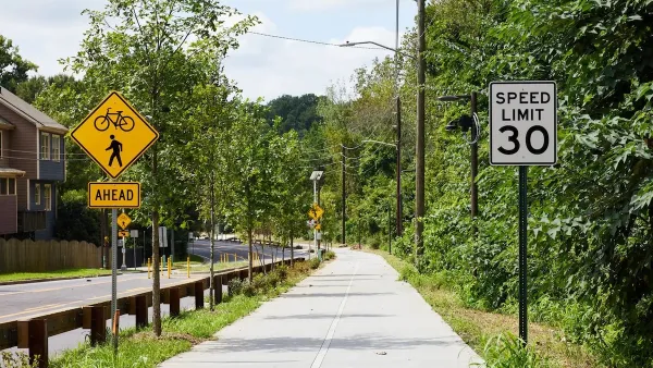 Paved Atlanta Beltline trail segment next to street with bike and pedestrian crossing sign and 30 mph speed limit sign.