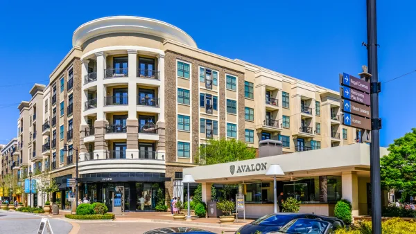 A mid-rise building with retail and apartments. A car port announces the name of the development: Avalon.