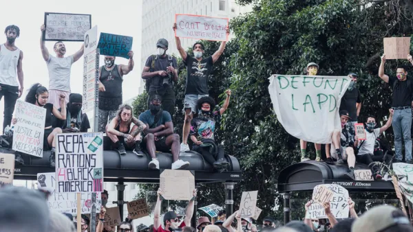 A group of protestors support Black Lives Matter and call for police reforms while gathered on top of a bus stop in Los Angeles.
