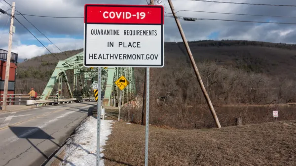 An image of a bridge in Vermont with a sign in front of it announcing a COVID-19 quarantine order.