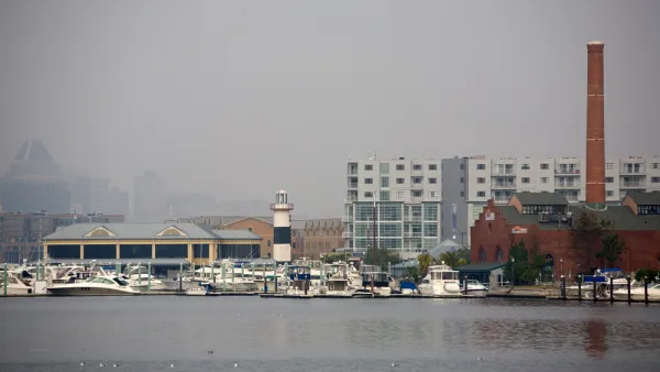 The city of Baltimore's Inner Harbor blanketed in fog, as seen from the water.