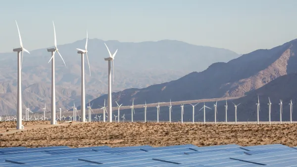 Wind turbines and solar panels against a backdrop of mountains in the Mojave Desert near Palm Springs, California