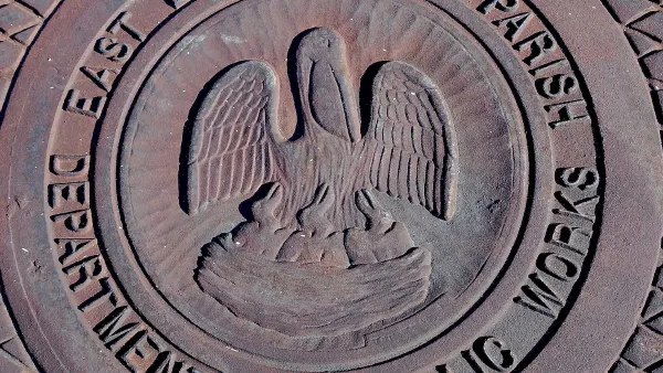 Close-up of metal manhole cover with pelican logo and 'East Baton Rouge Parish Department of Public Works.'