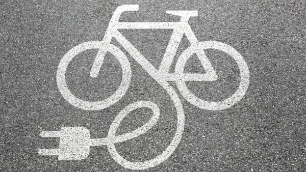 Electric bike charging logo on asphalt