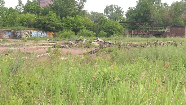 Vacant grassy lot with some cemet debris in Detroit, Michigan