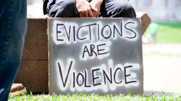Person holding sign that says "Evictions are violence"