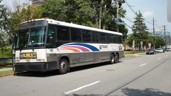 White NJ Transit parked at station with blue stripes.